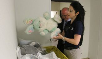 Barbara Gonzalez, public information officer for Immigration and Customs Enforcement, shows donated stuffed animals in an area where immigrant families are housed at the Artesia Residential Detention Facility inside the Federal Law Enforcement Center in Artesia, New Mexico. (AP Photo/Pool, El Paso Times, Rudy Gutierrez)