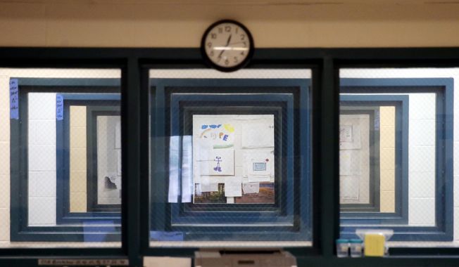 In this June 26, 2014, file photo, inmates’ art work decorating a group therapy room is visible through the windows of three adjacent interview rooms inside Cermak Health Services, the infirmary of the Cook County Jail. In the therapy room inmates with the most pressing mental health needs explore music and art. Many arrive already knowing doctors’ names, a sign not just that they’ve been there before, but that for many, the jail is their primary care provider, said Dr. Kenya Key, Cermak’s chief psychologist. (AP Photo/Charles Rex Arbogast) ** FILE **