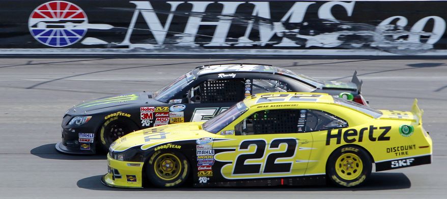 Brad Keselowski (22) slides down to pass Kyle Busch in turn two during the NASCAR Nationwide Series auto race at New Hampshire Motor Speedway Saturday, July 12, 2014, in Loudon, N.H. Keselowski went on to win the race, Busch came in second. (AP Photo/Jim Cole)