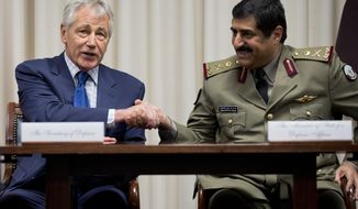 Defense Secretary Chuck Hagel, left, shakes hands with Qatari Defense Minister Hamad bin Ali al-Attiyah, at the Pentagon, Monday, July 14, 2014, during a signing ceremony. (AP Photo/Manuel Balce Ceneta)