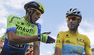 Spain&#39;s Alberto Contador gestures when talking to Italy&#39;s Vincenzo Nibali, wearing the overall leader&#39;s yellow jersey, prior to the start of the third stage of the Tour de France cycling race over 155 kilometers (96.3 miles) with start in Cambridge and finish in London, England, Monday, July 7, 2014. (AP Photo/Christophe Ena)
