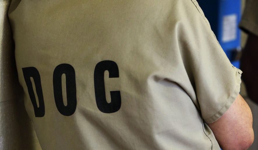 In this June 26, 2014 photo, an inmate uses a phone at the Cook County Jail in Chicago. Unlike prisons where inmates serve extended sentences, jails hold those trying to make bail while awaiting trial, or serving shorter terms. Experts have pointed to rising number of inmates with mental illnesses since the 1970s, not long after states began closing psychiatric hospitals without following through on promises to create and sustain comprehensive community treatment programs. (AP Photo/Charles Rex Arbogast)