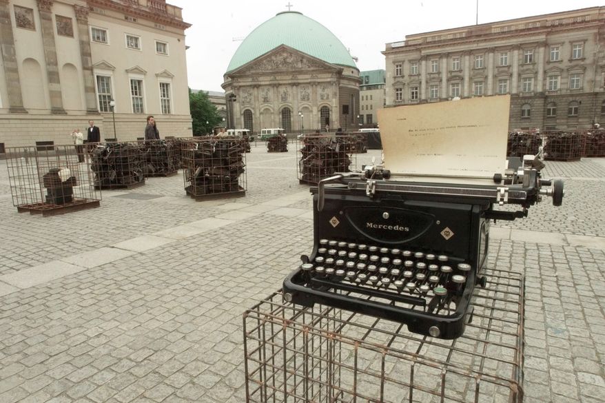 **FILE** The "Writer's Block" in Berlin's Bebel Square marks on May, 10, 1999, the 60th anniversary of a mass-burning of books 66 years ago. Cages filled with typewriters from the twenties and thirties sit on the squares, where Nazis burnt books of foreign and German writers on May 10, 1933. The display by Sheryl Oring from Grand Forks, North Dakota is accompanied by a dance performance. (Associated Press)