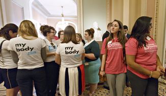 Women activists representing the National Women&#x27;s Law Center (left) and Planned Parenthood stand outside the Senate chamber after Senate Democrats&#x27; effort to proceed on the “Protect Women’s Health From Corporate Interference Act,” was thwarted, on Capitol Hill in Washington on July 16, 2014. Democrats sponsored the election-year bill to reverse last month&#x27;s Supreme Court ruling that closely held businesses with religious objections could deny coverage under President Barack Obama&#x27;s health care law. (Associated Press) **FILE**