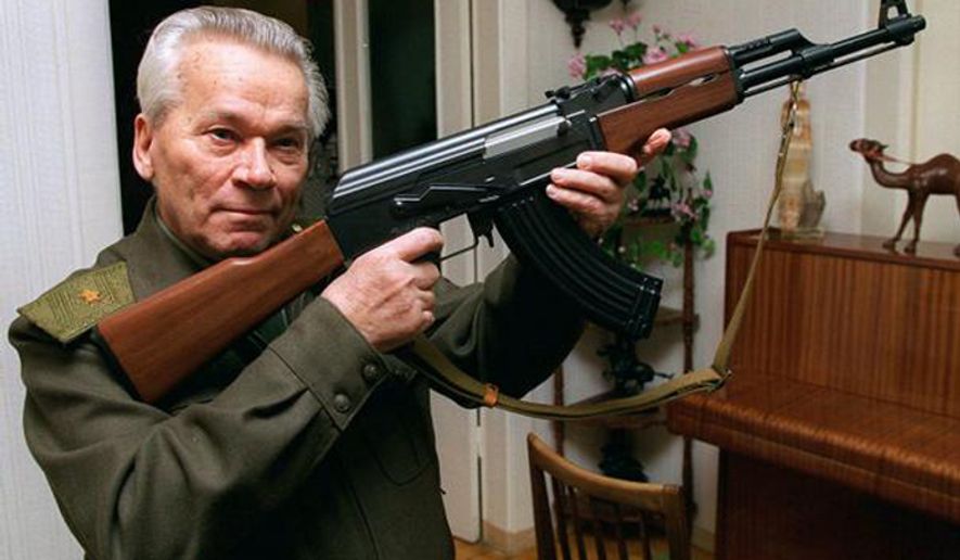 ** FILE **  Mikhail Kalashnikov shows a model of his world-famous AK-47 assault rifle at home in the Ural Mountain city of Izhevsk in 1997.  (Associated Press)
