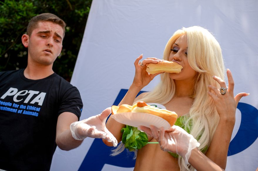 19 year old model and television personality Courtney Stodden dressed in a lettuce bikini takes a bite out of a veggie dog as she hands them out for this years PETA Congressional Veggie Dog Giveaway outside the Rayburn Office Building on Capitol Hill, Washington, D.C., Wednesday, July 16, 2014. PETA holds the giveaway in response to the meat industry's annual Hot Dog Lunch on National Hot Dog Day. (Andrew Harnik/The Washington Times)