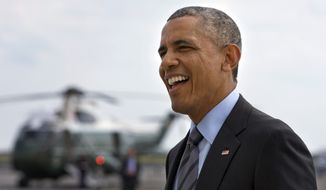 President Barack Obama smiles at a group of people welcoming him as he arrives in New York where he will attend fundraisers Thursday, July 17, 2014. (AP Photo/Jacquelyn Martin)