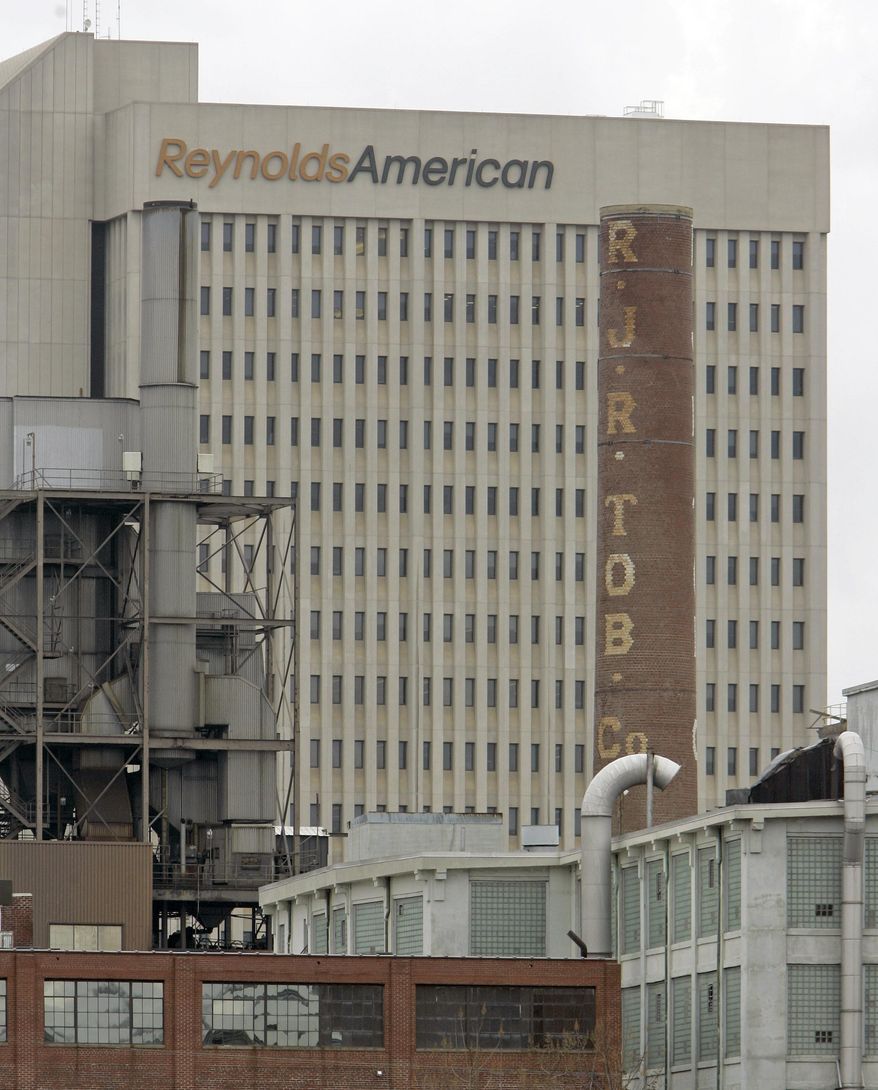 In this Feb. 6, 2008 photo, a smokestack of an old R.J. Reynolds Tobacco plant frames the Reynolds American building in Winston-Salem, N.C., A Florida jury has slammed R.J. Reynolds Tobacco Co. with $23.6 billion in punitive damages in a lawsuit filed by Cynthia Robinson, the widow of a longtime smoker who died of lung cancer in 1996. The damages the jury awarded to Robinson on Friday, July 18, 2014, after a four-week trial come in addition to $16.8 million in compensatory damages. (AP Photo/Chuck Burton)