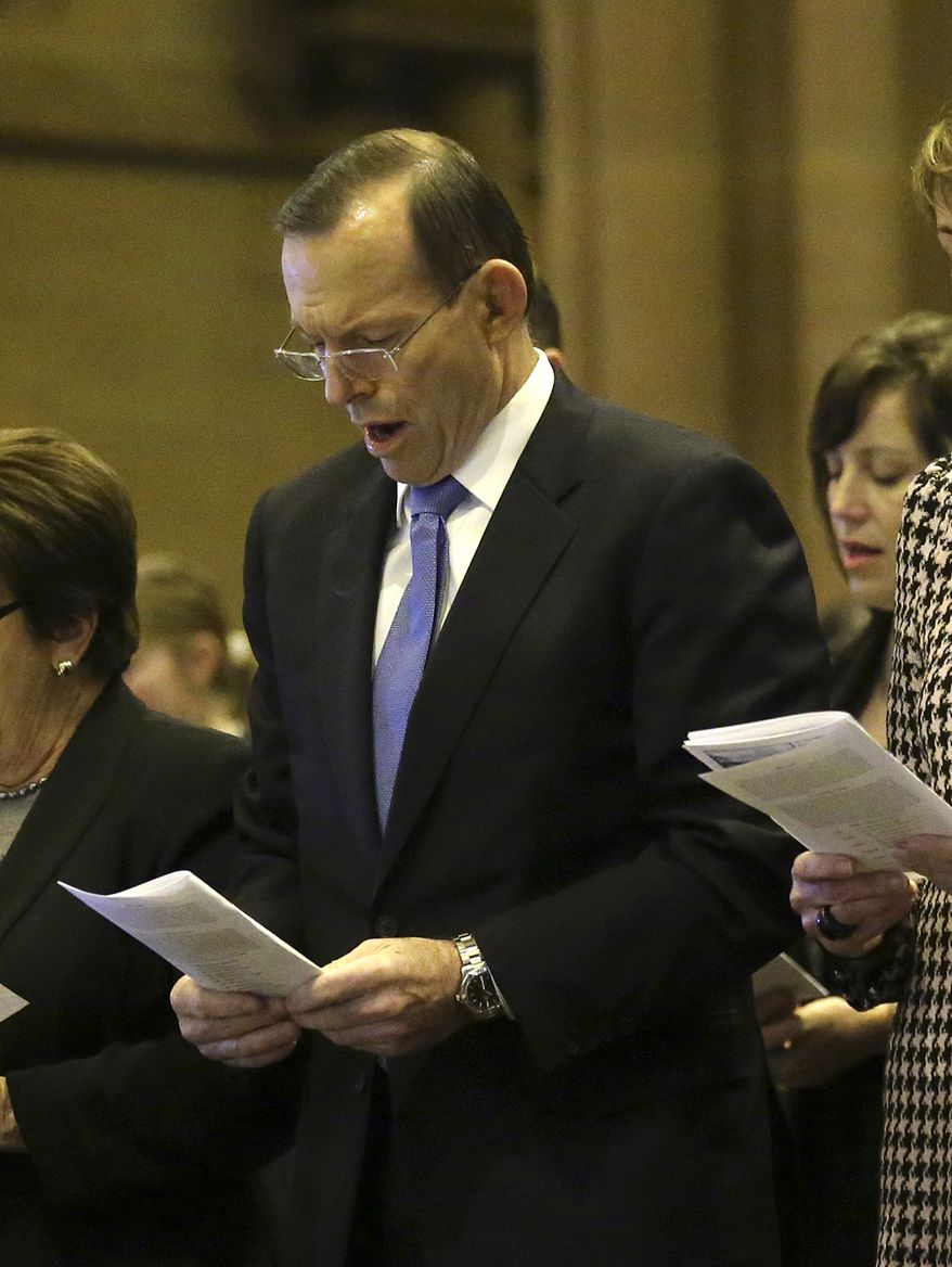 ** FILE ** Australia's Prime Minister Tony Abbott sings a hymn during a Mass at St. Mary's Cathedral commemorating victims of Malaysia Airlines Flight 17 in Sydney, Australia, Sunday, July 20, 2014.(AP Photo/Rob Griffith)