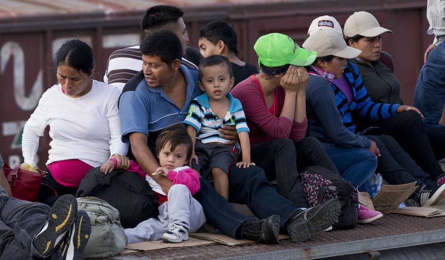 In this July 12, 2014, photo, Central American migrants ride a freight train during their journey toward the U.S.-Mexico border in Ixtepec, Mexico. The number of family units and unaccompanied children arrested by Border Patrol in the Rio Grande Valley has doubled in the first nine months of this fiscal year compared to the same period last year.  (AP Photo/Eduardo Verdugo)