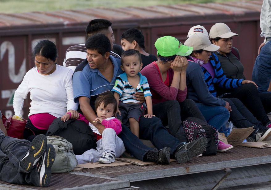 In this July 12, 2014, photo, Central American migrants ride a freight train during their journey toward the U.S.-Mexico border in Ixtepec, Mexico. The number of family units and unaccompanied children arrested by Border Patrol in the Rio Grande Valley has doubled in the first nine months of this fiscal year compared to the same period last year.  (AP Photo/Eduardo Verdugo)