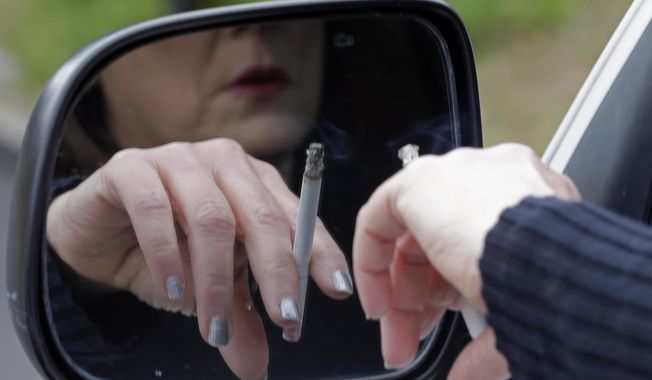A woman smokes a cigarette. (Associated Press) ** FILE **