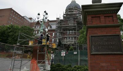 ** FILE ** In this May 19, 2005, file photo, construction workers work on part of the Johns Hopkins Hospital in Baltimore. (AP Photo/Chris Gardner, File)