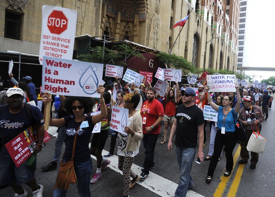 Protesters march over the controversial water shut-offs Friday, July 18, 2014, in Detroit, Mich. (AP Photo/Detroit News, David Coates)