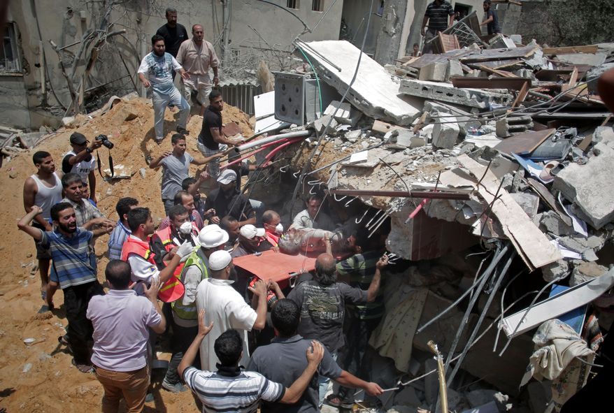 Palestinian rescuers release a lifeless body from the rubble of a house was destroyed by an Israeli missile strike, in Gaza City, Monday, July 21, 2014. On Sunday, the first major ground battle in two weeks of Israel-Hamas fighting exacted a steep price, killing scores of Palestinians and over a dozen Israeli soldiers and forcing thousands of terrified Palestinian civilians to flee their devastated Shijaiyah neighborhood, which Israel says is a major source for rocket fire against its civilians. (AP Photo/Khalil Hamra)