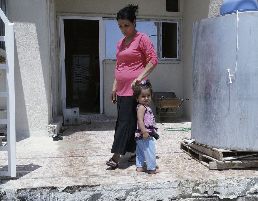 ** FILE ** In this Sunday, July 20, 2014, photo, newly arrived displaced Christians wait for relief aid at a church in the town of Hamadaniya, 25 miles (40 kilometers) north of Mosul, Iraq. Iraqi Christians have been fleeing from the northern city of Mosul in the wake of threats from Islamic State militants who took the city in a blitz offensive last month. (AP Photo)