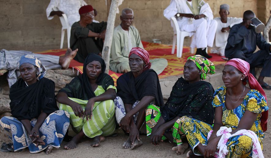 Some of the parents of the kidnapped school girls sit outside a compound during a meeting in Chibok, Nigeria. At least 11 parents of the more than 200 kidnapped Nigerian schoolgirls will never see their daughters again. Since the mass abduction of the schoolgirls by Islamic extremists three months ago, at least 11 of their parents have died and their hometown, Chibok, is under siege from the militants, residents report. (AP Photo/Sunday Alamba, File)