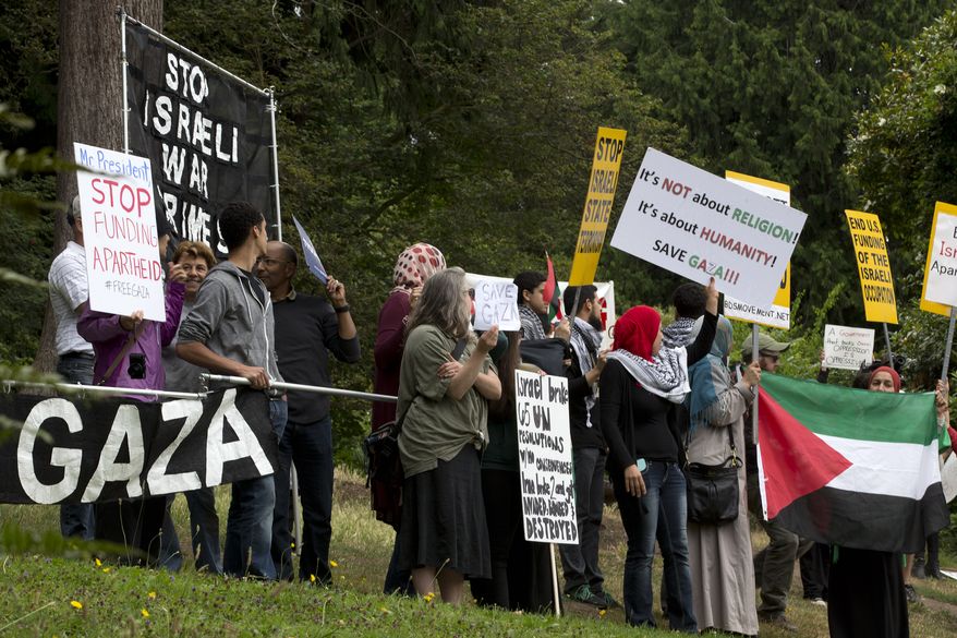 Pro-Palestinian protesters chant near a private residence where President Barack Obama had arrived to attend a fundraiser in Seattle Tuesday, July 22, 2014, the start of a three-day West Coast trip that is planned to include at least five fundraising events in Seattle, San Francisco and Los Angeles. (AP Photo)