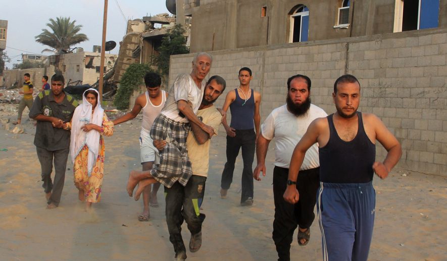 A Palestinian man carries his father as he and others run to take cover during an Israeli air strike in Rafah on Wednesday. (Associated Press photographs)