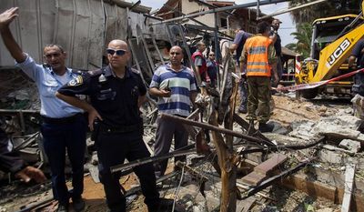 Israeli police officers secure a destroyed house that was hit by a rocket fired by Palestinians militants from Gaza, in Yahud, a Tel Aviv suburb near the airport, central Israel, Tuesday, July 22, 2014. As a result, Delta Air Lines and U.S. Airlines decided to cancel their scheduled flights to Israel.(AP Photo/Dan Balilty)