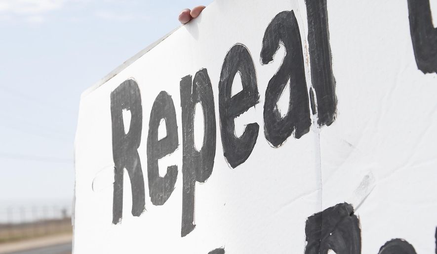 Robert Hungerford, of Phoenix, prays as he and a group of about a dozen death penalty opponents protest the possible execution of Joseph Rudolph Wood at the state prison in Florence, Ariz. on Wednesday, July 23, 2014. Arizona's highest court on Wednesday temporarily halted the execution of the condemned inmate so it could consider a last-minute appeal. The Arizona Supreme Court said it would consider whether he received inadequate legal representation at his sentencing. The appeal also challenges the secrecy of the lethal injection process and the drugs that are used. (AP Photo) **FILE**
