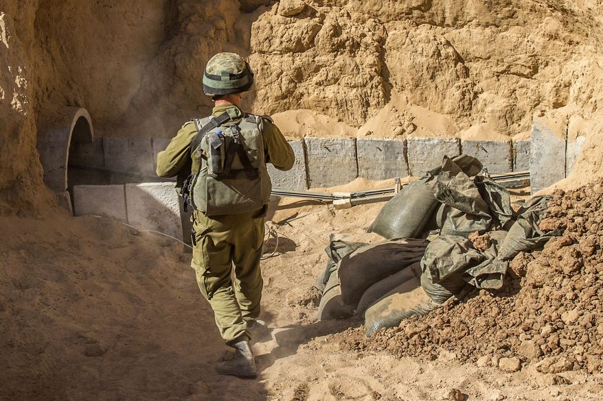 An Israeli army officer walks near the entrance of a tunnel, Friday, July 25, 2014, that is allegedly used by Palestinian militants for cross-border attacks, at the Israel-Gaza Border. A network of tunnels Palestinian militants have dug from Gaza to Israel, dubbed "lower Gaza" by the Israeli military, is taking center stage in the latest war between Hamas and Israel. (AP Photo/Jack Guez, Pool)