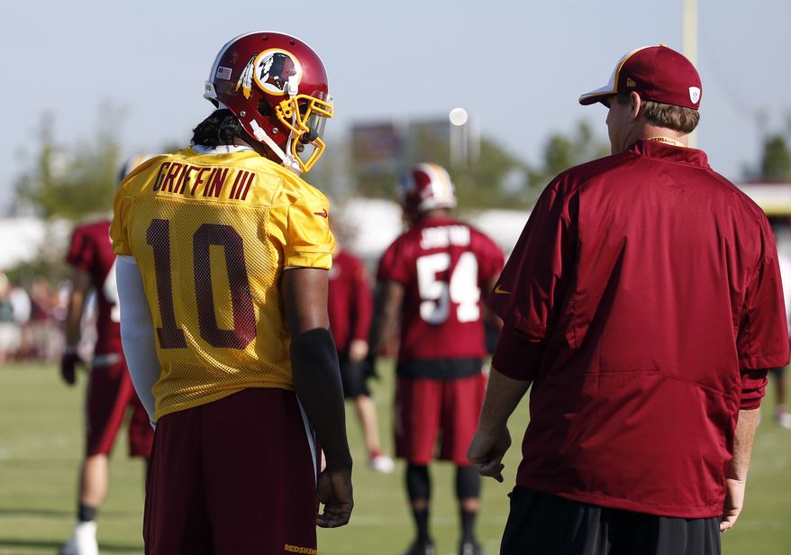 Washington Redskins quarterback Robert Griffin III talks with head coach Jay Gruden during practice at the team's NFL football training facility, Friday, July 25, 2014 in Richmond, Va. (AP Photo)
