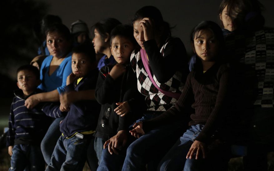FILE - This June 25, 2014, file photo shows a group of immigrants from Honduras and El Salvador who crossed the U.S.-Mexico border illegally are stopped in Granjeno, Texas. Even as they grapple with an immigration crisis at the border, White House officials are making plans to act before November’s mid-term elections to grant work permits to potentially millions of immigrants in this country illegally, allowing them to stay in the United States without threat of deportation, according to advocates and lawmakers in touch with the administration. (AP Photo/Eric Gay, File)