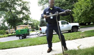 FILE-- In this July 8, 2014 file photo, Chester Clemons, a water shut-off technician for the city of Detroit, shuts off the water at a home in the Palmer Woods neighborhood of Detroit.  State-appointed emergency manager Kevyn Orr issued an order placing control of Detroit’s water department in the hands of Mayor Mike Duggan. The move was announced Tuesday, July 29, 2014 and comes as the massive water system in the bankrupt city has received national and international criticism for shutting off service to thousands of customers who are 60 days or more behind on their bills. (AP Photo/The Detroit News, Elizabeth Conley)