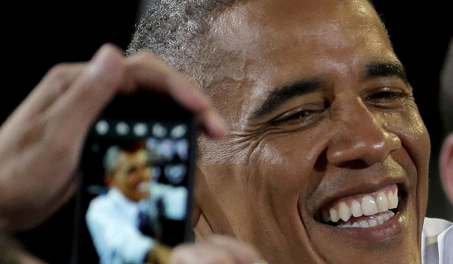 A guest uses their cellphone to photograph President Barack Obama as greets the crowd after speaking about the economy, Wednesday, July 30, 2014, at the Uptown Theater in Kansas City, Mo. (AP Photo/Charlie Riedel) ** FILE **