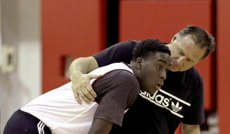 North Carolina State coach Mark Gottfried, right, speaks with Abdul-Malik Abu during an NCAA college basketball workout in Raleigh, N.C., Wednesday, July 30, 2014. Abu is determined to give North Carolina State some help inside as the Wolfpack tries to move on after losing the top player in the Atlantic Coast Conference. (AP Photo/Gerry Broome)