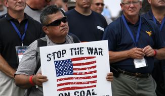 A member of the Boilermakers local 154 Pittsburgh holds a sign at a rally to support American energy and jobs in the coal and related industries at Highmark Stadium in downtown Pittsburgh, Wednesday, July 30, 2014. The rally is being held the day before the Environmental Protection Agency conducts public hearings on its new emissions regulations for existing coal fired power plants. (AP Photo/Gene J. Puskar)