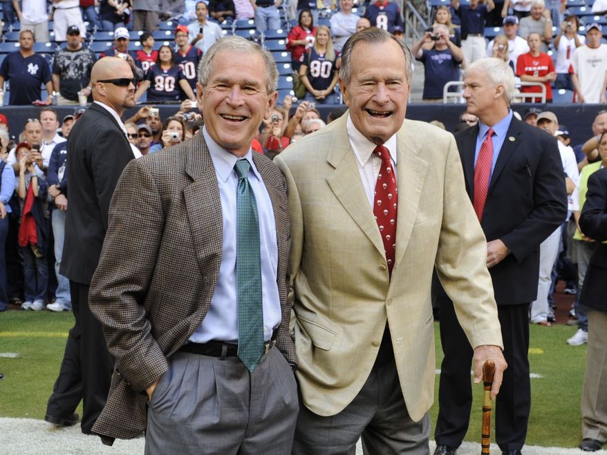 ** FILE ** This Oct. 25, 2009, file photo shows former Presidents George H. W. Bush, right, and George W. Bush before the Houston Texans NFL football game against the San Francisco 49ers in Houston. (AP Photo/Dave Einsel, File)