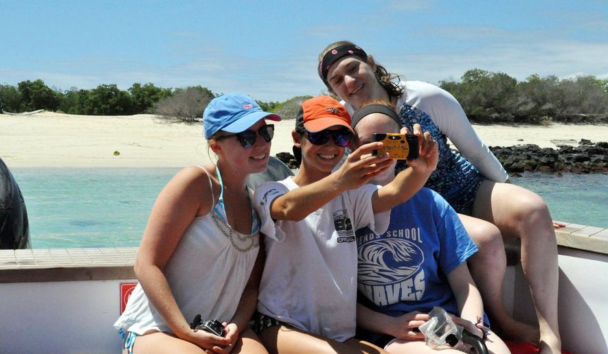 Four vacationers on holiday record the moment with a selfie in this file photo. (AP Photo Jacqui Whitt) **FILE**