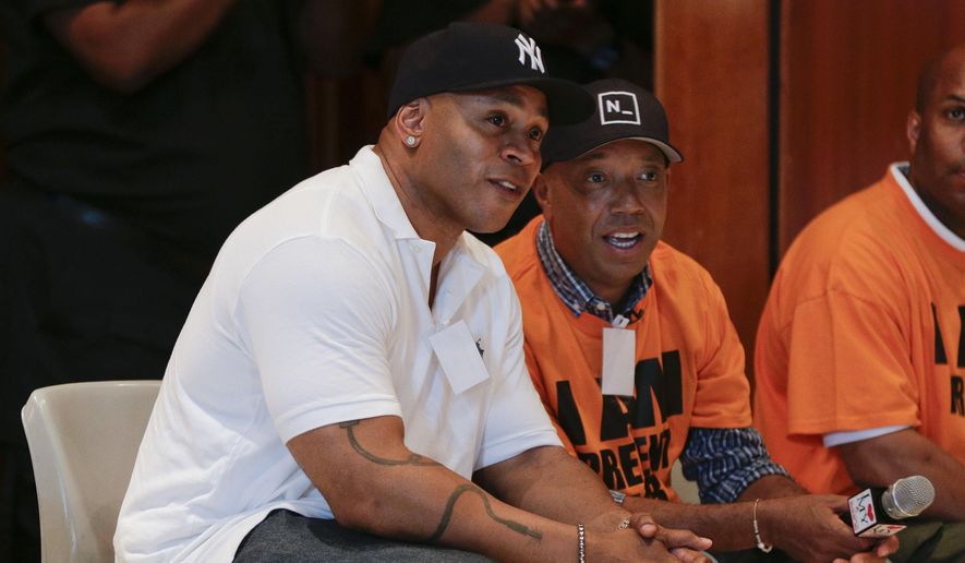 Actor and music artist L.L. Cool J, left, talks with Def Jam co-founder Russell Simmons on a visit to speak with youth at the juvenile detention center of Rikers Island, Thursday, July 31, 2014, in New York. Simmons, founder of the RushCard Keep the Peace initiative, was accompanied by L.L. Cool J to the detention center to offer advice to the inmates on reducing violence in their neighborhoods. (AP Photo/Julie Jacobson)