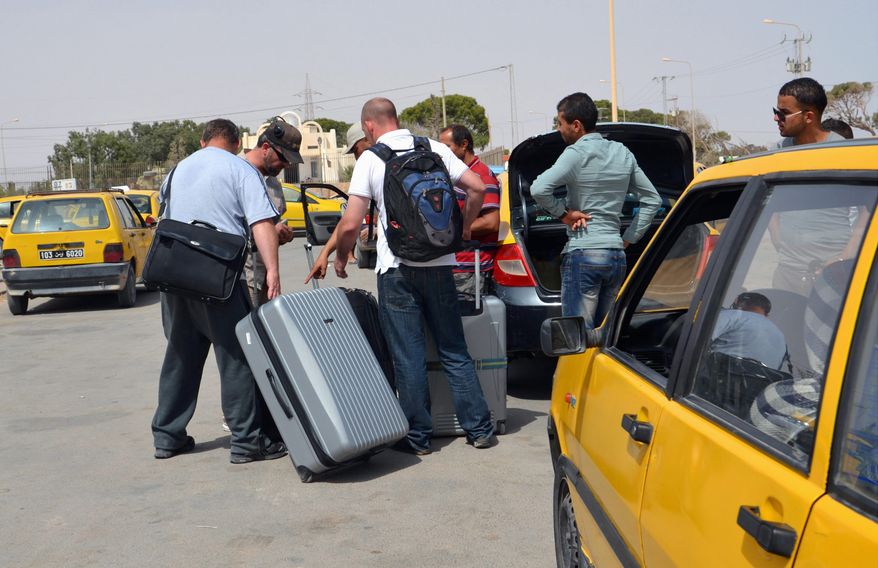 Tunisian taxi drivers wait for clients fleeing from Libya at the border between Libya and Tunisia. Up to 6,000 people a day have fled Libya into neighboring Tunisia this week, the Tunisian foreign minister said, the biggest influx since Libya's 2011 civil war in a sign of the spiraling turmoil as rival militias battle over control of the airport in the capital Tripoli. (Associated press photographs)