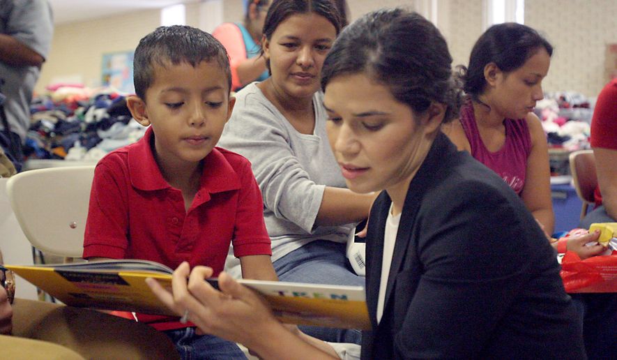 Actress America Ferrera reads a book to a Central American immigrant boy during her visit with the Hispanic Heritage Foundation humanitarian project, Monday July 28, 2014, at a Sacred Heart Church shelter in McAllen, Texas. The program focuses on providing the children with hope and relief from their plight through reading, playing and praying. (AP Photo/The Monitor, Delcia Lopez)