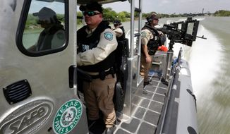 ** FILE ** Texas Parks &amp; Wildlife Wardens patrol the Rio Grand on the U.S.-Mexico border in Mission, Texas. Texas is spending $1.3 million a week for a bigger presence from the Department of Public Safety along the border. (Associated Press)
