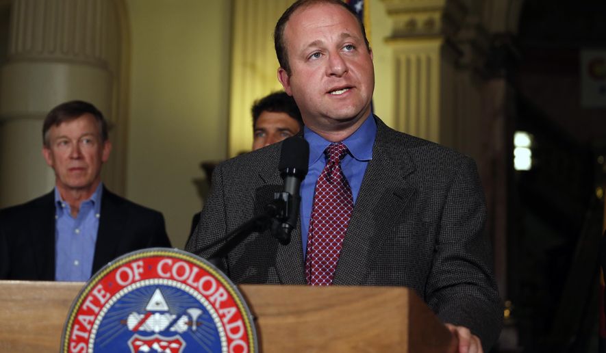 In this file Aug. 4, 2014 photo, U.S. Rep. Jared Polis, D-Colo., takes questions during a news conference about fracking, as Colo. Gov. John Hickenlooper, left, stands at left, inside the Capitol, in Denver. (AP Photo/Brennan Linsley, file)