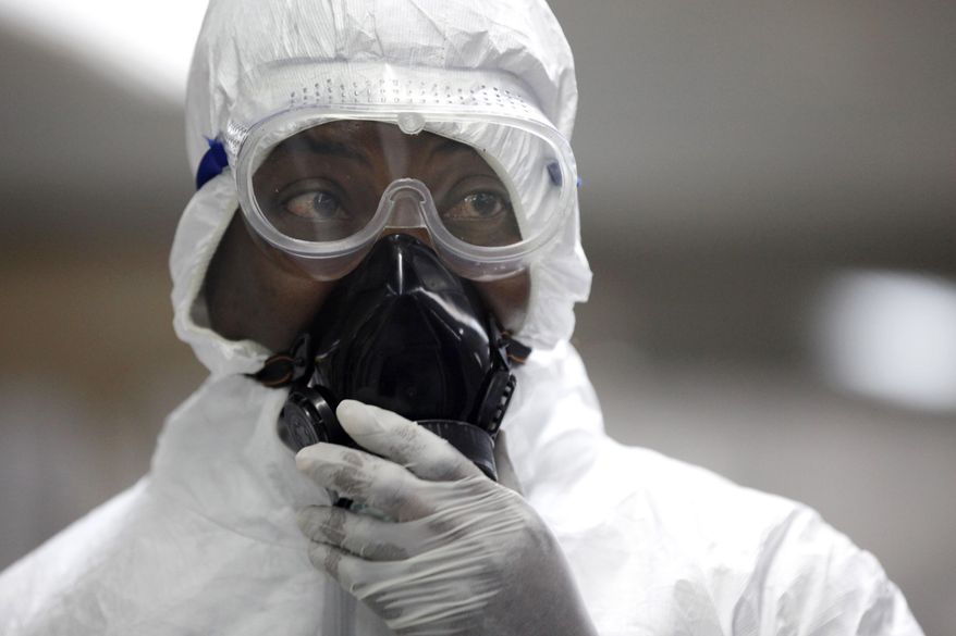 A Nigerian health official wearing a protective suit waits to screen passengers at the arrivals hall of Murtala Muhammed International Airport in Lagos, Nigeria, Monday, Aug. 4, 2014. Nigerian authorities on Monday confirmed a second case of Ebola in Africa's most populous country, an alarming setback as officials across the region battle to stop the spread of a disease that has killed more than 700 people. (AP Photo/Sunday Alamba)