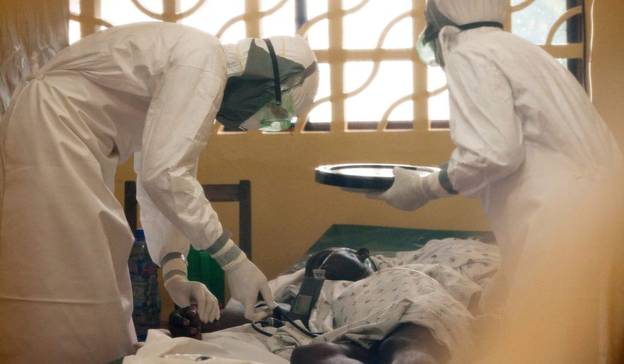 ** FILE ** In this 2014 photo provided by the Samaritan&#39;s Purse aid organization, Dr. Kent Brantly, left, treats an Ebola patient at the Samaritan&#39;s Purse Ebola Case Management Center in Monrovia, Liberia. (Associated Press)