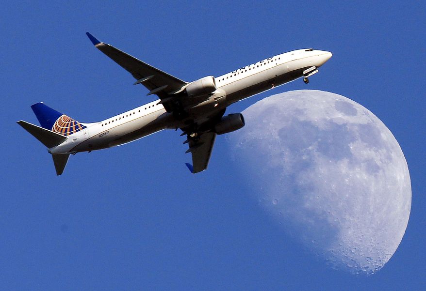 ** FILE ** A United Airlines jet approaches Los Angeles International Airport passes in front of a Waxing Gibbous moon July 17, 2013. ( AP Photo/Nick Ut, File)