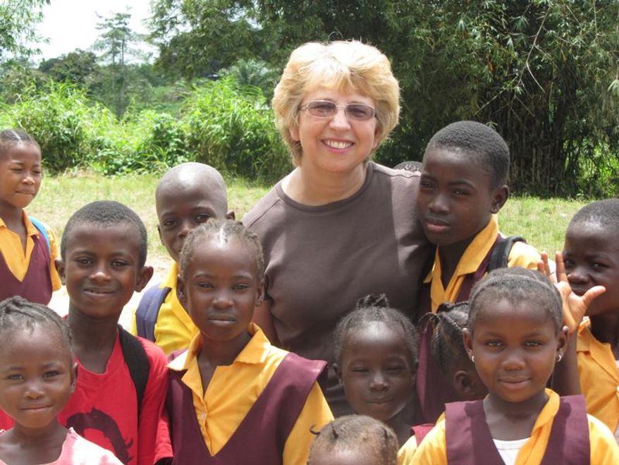 This Oct. 7, 2013 photo provided by Jeremy Writebol show his mother, Nancy Writebol, with children in Liberia. Writebol is one of two Americans working for a missionary group in Liberia that have been diagnosed with Ebola. Plans are underway to bring back the two Americans from Africa for treatment. (AP Photo/Courtesy Jeremy Writebol)
