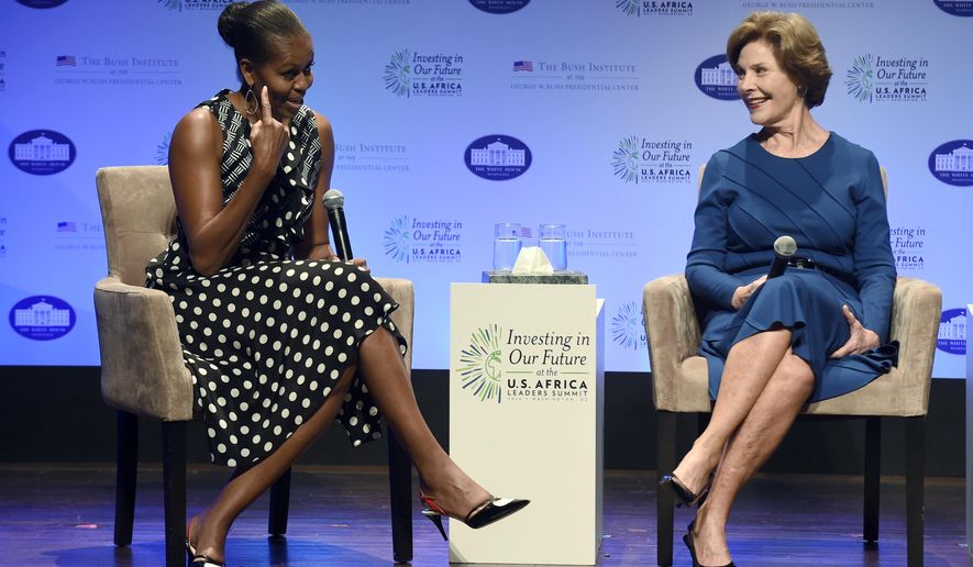 First lady Michelle Obama, left, points out her hairstyle as she sits with former first lady Laura Bush as they participate in the &amp;quot;Investing in Our Future&amp;quot; a discussion at the Kennedy Center in Washington, Wednesday, Aug. 6, 2014, as part of the US Africa Summit. Michelle Obama and Laura Bush, first ladies of different generations and opposing political parties, are uniting for the second time in just over a year to promote U.S. relations with Africa. (AP Photo/Susan Walsh)
