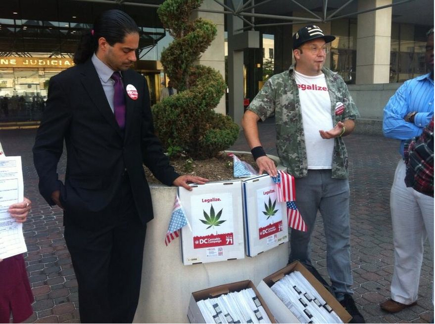 Activists Nikolas Schiller (left) and Adam Eidinger (right) outside the D.C. Board of Elections display some 57,000 petition signatures collected in support of a referendum to legalize marijuana (Andrea Noble/The Washington Times)