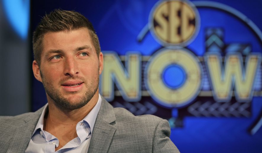 Tim Tebow ponders a question during an interview on the set of ESPN's new SEC Network in Charlotte, N.C., Wednesday, Aug. 6, 2014. Tebow has a new job as a commentator for the SEC Network, but is still looking for work in the NFL as a quarterback. (AP Photo/Chuck Burton)