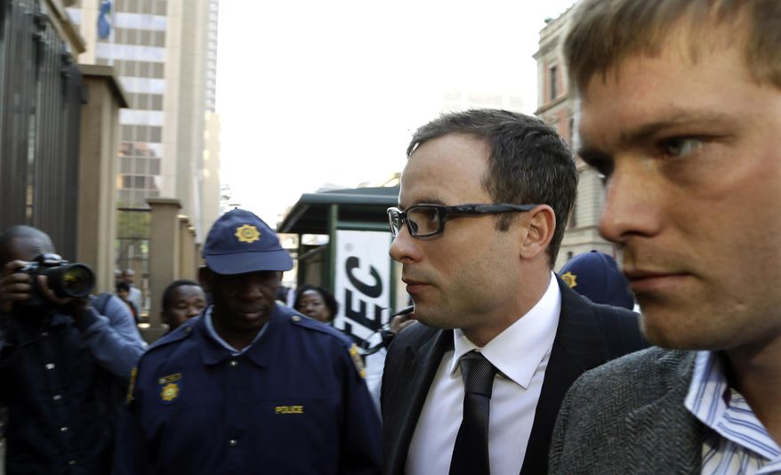Oscar Pistorius, second from right, accompanied by a relative arrives at the high court in Pretoria, South Africa, Thursday, Aug. 7, 2014. On Thursday and Friday, both sides will summarize their versions of the shooting to Thokozile Masipa, the red-robed judge who will determine the fate of the double-amputee Olympic runner. (AP Photo/Themba Hadebe)