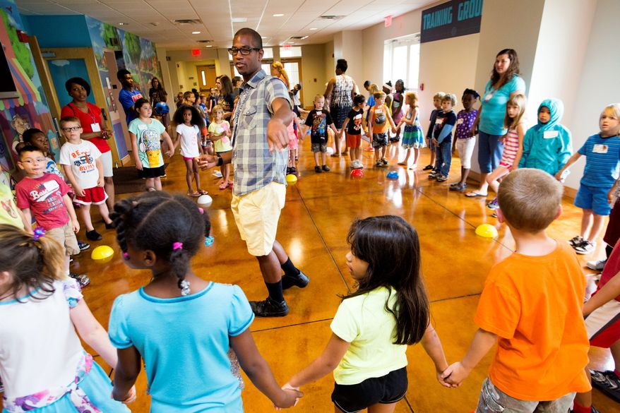 Jonathan Cogdell (center) leads an activity with 6-year-olds during the last day of vacation Bible school.