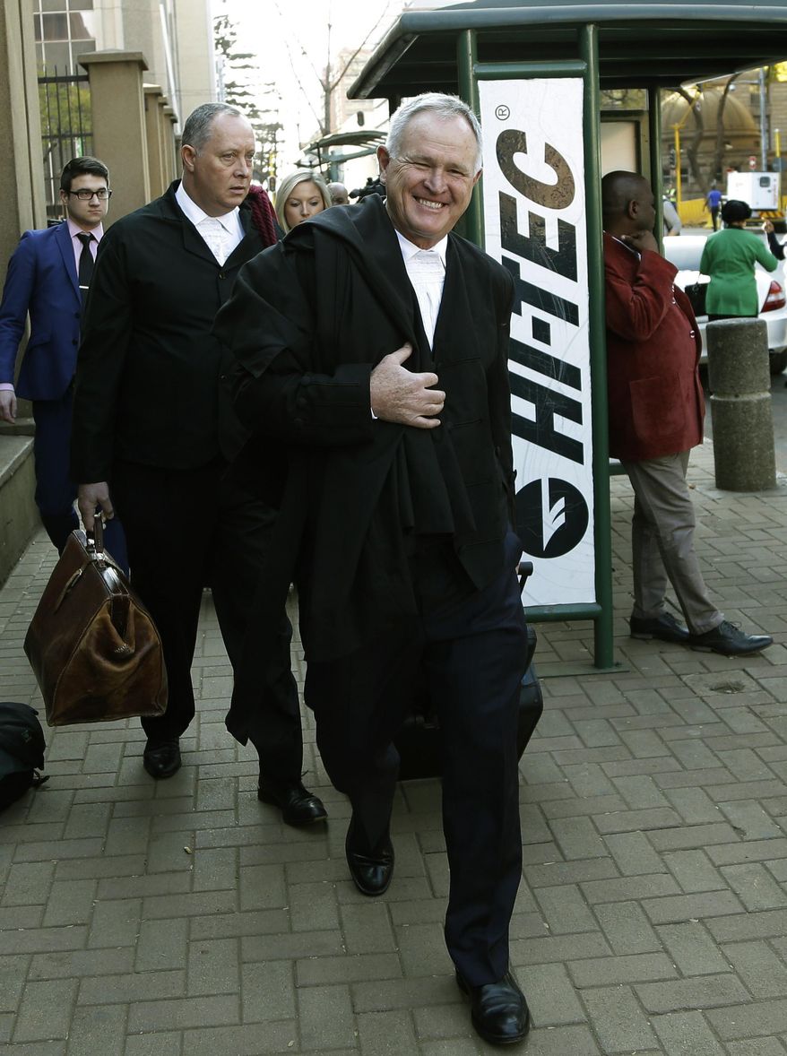 Barry Roux, front, the lawyer defending Oscar Pistorius, accompanied by his team, arrives at the high court in Pretoria, South Africa, Thursday, Aug. 7, 2014. On Thursday and Friday, both sides will summarize their versions of the shooting to Thokozile Masipa, the red-robed judge who will determine the fate of the double-amputee Olympic runner. (AP Photo/Themba Hadebe)