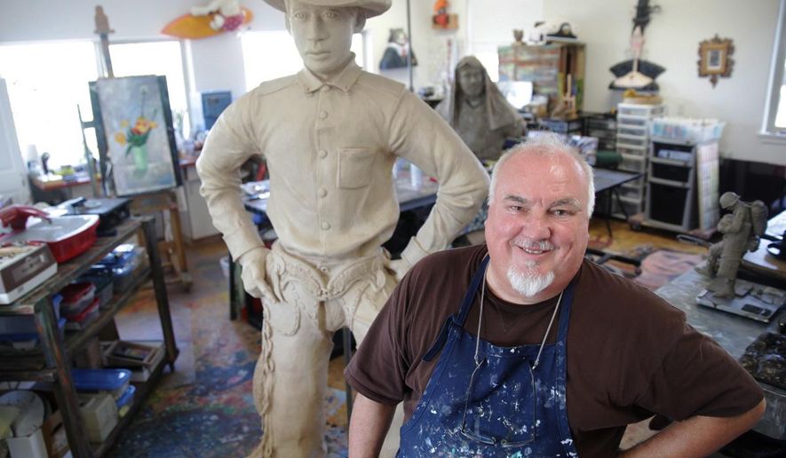 In this July 30, 2014 photo, artist Jerry Werner stands with his sculpture of George Fletcher in his studio in Tumalo, Ore. When Werner heard Pendleton, Ore. was looking for an artist to create a bronze sculpture of a rodeo cowboy for its downtown, he wasn’t interested. Then, he heard the story behind the particular cowboy - a story steeped in rodeo, racial injustice and the changing face of the American West. (AP Photo/The Bulletin, Meg Roussos)
